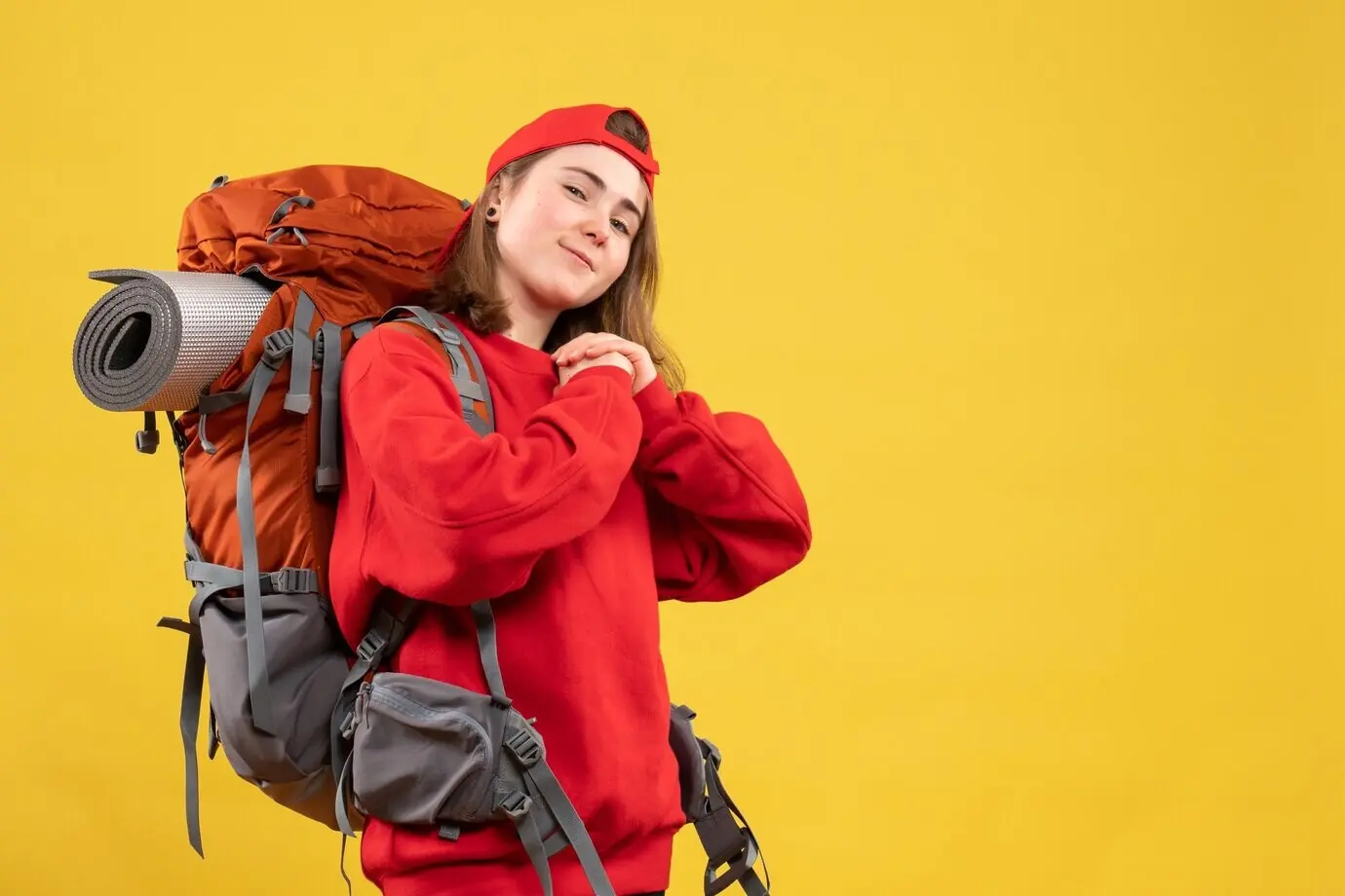 Vorderansicht einer hübschen weiblichen Reisenden, die die Hände zusammenhält.