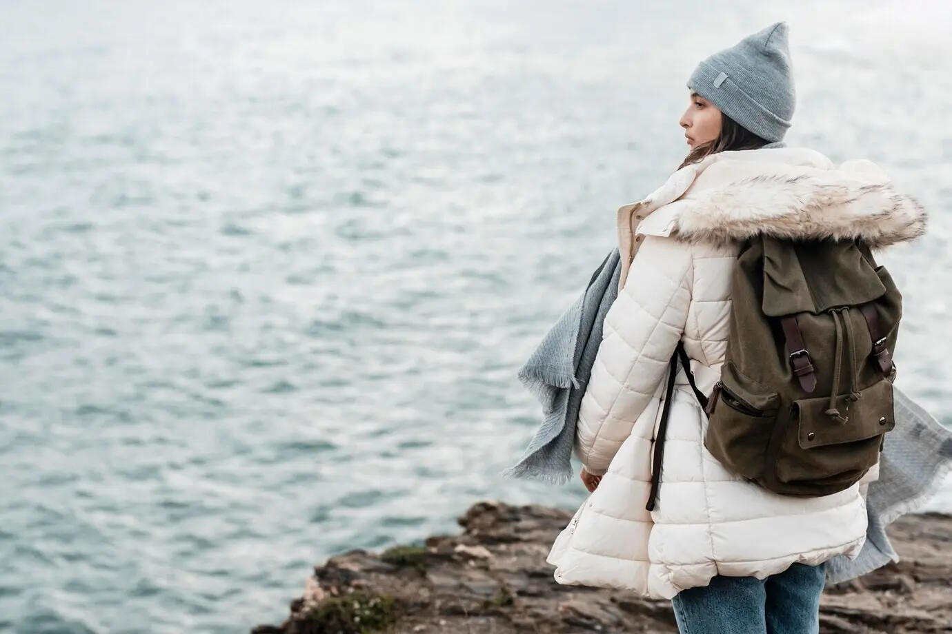 Rückansicht einer Frau, die die Aussicht auf den Ozean bewundert, mit Platz für Text.
